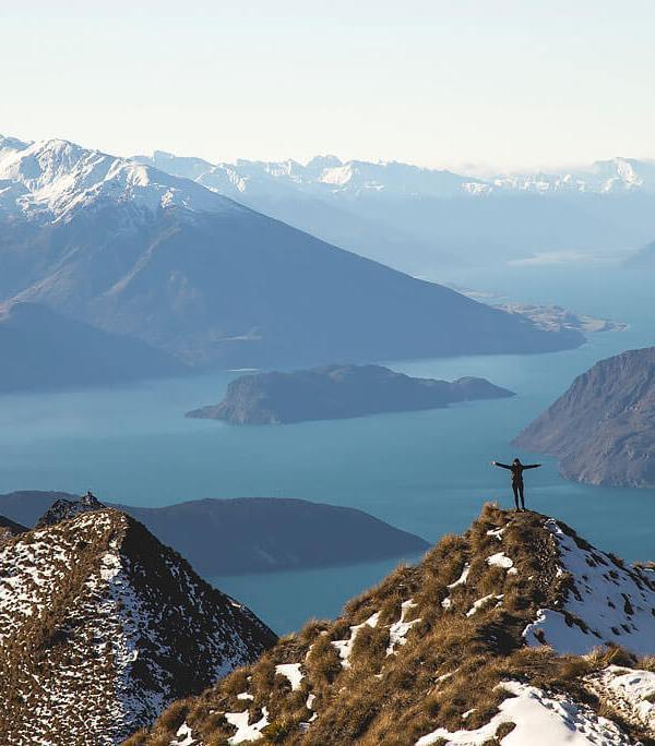 man standing on top of roy's peak